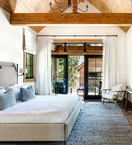 The tongue-and-groove wood ceiling in a bedroom seamlessly matches the exterior porch ceiling for continuity between inside and out.