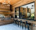 A chandelier from Shades of Light illuminates the outdoor grill station, accessed by a pass-through window from the kitchen.