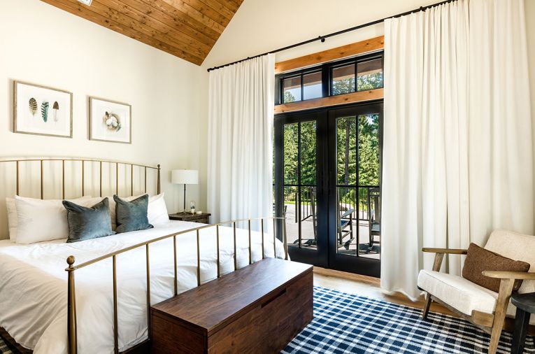 The bedrooms all received custom blackout window treatments from Shades of Elegance. Here, a Crate & Barrel bed frame was placed with a CB2 trunk and Annie Selke rug, the latter from J Garner Home.