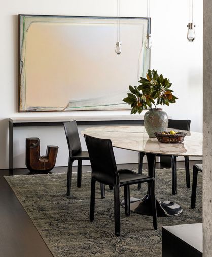In the dining room, the painting “Long Beach” by Michael Dailey sits above a whitewashed-poplar and blackened-steel console from Chadhaus. The Eero Saarinen Tulip Table is surrounded by Cassina Cab chairs from Inform Interiors, atop a rug from Driscoll Robbins. “It was important to me that the rug corresponded to the dark floor,” says Hellstern.