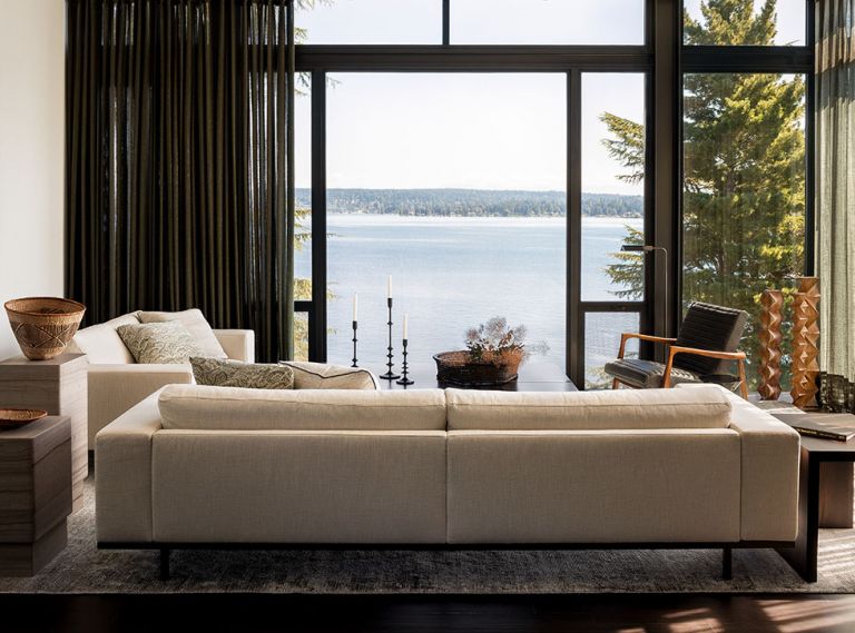 In the living room, two Piet Boon couches from Inform Interiors are flanked by Piet Boon marble side tables on one side, and a custom “Via” side table designed by Charlie Hellstern for the ‘Loom Collection’ and built by Stusser Woodworks Inc. The large-scale painting is by Tony Scherman, and Aleph Geddis carved the wood sculptures in the corner.