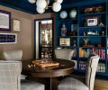 In the games room, a Theodore Alexander table from DFG at the Seattle Design Center sits with CR Laine chairs. Custom shelving, designed by Rowland and built by Superior Cabinets, is painted a blue hue by Benjamin Moore, to sync with the sepia tones of the Schumacher map wallpaper above. The artwork is from the homeowners’ collection, reflecting their love of travel. “Rebecca is kind-of magic,” says Frederica, of how the designer threads elements together.