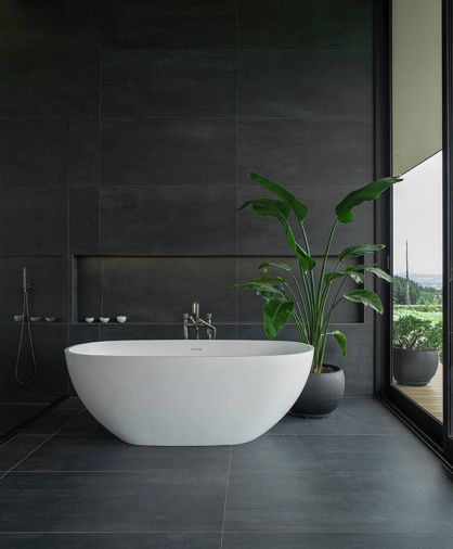 A soaking tub from Badeloft USA sits against floor and wall tile by Fiandre. “It’s a large scale, almost black tile that has a painterly movement to the surface,” says Cruse. “I didn’t want flat colors. Everything has some muddiness to it, so it feels more alive.” Photography © Peter Eckert