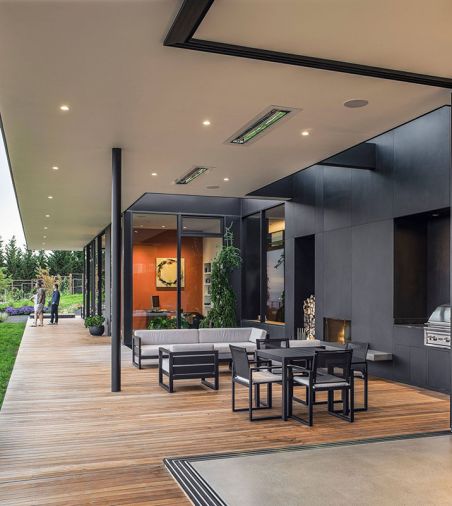 A covered deck acts as an intermediary between the house and yard, feeding into an outdoor entertainment space. Photography © Peter Eckert