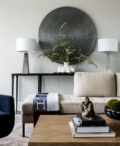 A high-pile Turabi Rug Gallery rug grounds The Dixon Group’s Robert James coffee table. Blu Dot chaises play off Made Good lamps flanking metal Mitchell Gold & Bob Williams wall ornament. Playful woman’s bust vase.