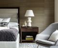 n the primary bedroom, a textural Kneedler Fauchere wallcovering offsets the custom bed frame, with a custom rug from Driscoll Robbins and a Saarinen-style Womb chair through Modern Classics Furniture bringing modern coziness.