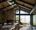 Conference room in north house doubles as guest room. Stefan Gulassa transformed a salvaged wisteria branch from dilapidated deck into chandelier. Sawkille Co. table. Chadhaus Studio Chairs. Insulated original roof and skylights above. Photography © Kevin Scott