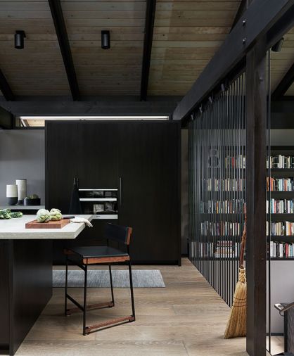 Token Catenary Counter Stool becomes part of a moveable office with printer stored in island. Two-story steel curtain right acts as safety rail. Hellstern’s smoked walnut stained Tansu style custom casework by William Walker Woodworking houses refrigerator right, freezer left, espresso center. Photography © Kevin Scott