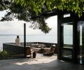 New prow deck on south house overlooks water. Previous deck was redesigned and re-detailed with modern style. Local beach rock mosaic table tops custom designed side table by artist Nadine Edelstein. Photography © Kevin Scott