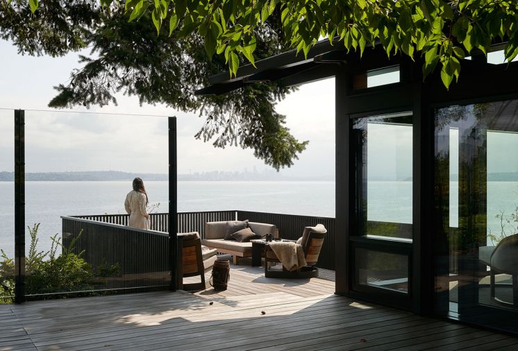 New prow deck on south house overlooks water. Previous deck was redesigned and re-detailed with modern style. Local beach rock mosaic table tops custom designed side table by artist Nadine Edelstein. Photography © Kevin Scott