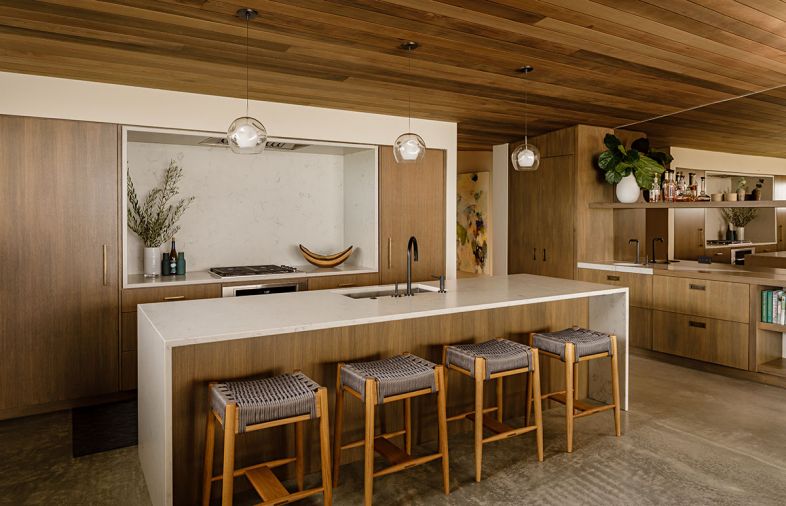 “This is my favorite kitchen to work in because it’s so open,” says Kari. “And so many people can work around the big island.” It’s wrapped in PentalQuartz, with a Blanco sink and Kallista faucet, from Ferguson. The stove niche sports the same stone, with a Wolf cooktop and Vent-A-Hood extractor above.