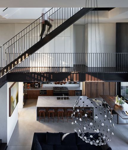 A suspended staircase to roof deck and gardens features double smoked oak engineered wood floors, perforated stairs, and steel guardrail.