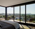 Primary bedroom’s DWR Matera Bed overlooks deck to view beyond.