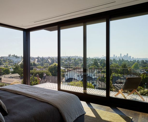 Primary bedroom’s DWR Matera Bed overlooks deck to view beyond.