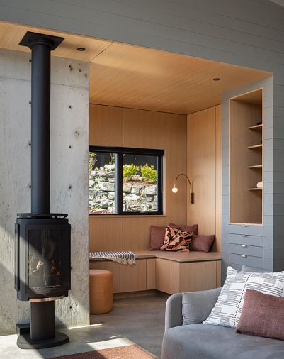 Linsenmayer reads or watches television in the nook. It’s defined from the main room by rift-sawn white oak veneered plywood, and finished with Rubio Monocoat in ‘Cornsilk.’ A Jotul fireplace warms the home.