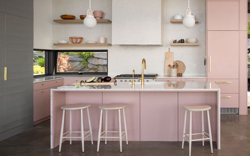 In the kitchen, the custom cabinets were built by local cabinetmaker Matthew Janowicz, and painted Benjamin Moore ‘Vintage,’ which contrasts gently with the tongue and groove cedar cabinet to the left, stained in Benjamin Moore Arborcoat ‘Chelsea Gray.’ Fireclay ceramic tile in Tusk covers the backsplash and stove hood, which has a Zephyr insert, and a LaCanche range sits below. The countertops are Statuario Gioia Marble, from EleMar Oregon, and the lighting is by Allied Maker.