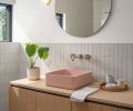 In the bathroom, a custom white oak vanity is bedecked with a pink Kast ‘Aria’ sink. The walls have ceramic tile from Fireclay, in 2x6 French Linen.