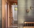 The rift-sawn white oak in the hall reveals a pink door to the laundry.