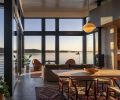 The architects placed the deck between the two glass volumes to protect from the elements. It has outdoor seating by Loll Designs and reclaimed redwood decking, and is accessed via Kolbe sliding doors from the living room. There, Knudsen combined a sofa from MENU Design Shop with sculptural Nido chairs by Estudio Persona from Spartan Shop, and a custom-colored rose-hued rug by June Hilton. The aluminum-clad windows are wood on the inside, and finished with Benjamin Moore Arborcoat in black, “just to give them a uniformity,” says Watzin. “Since you experience both sides of the windows from all different places.”