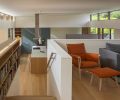 Custom white oak bookcases echoing the rhythm of clerestory windows that flank stairs to family room. Embrace Chair by Carl Hansen and Eoos Magnum sofa by Flex Form.