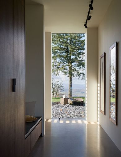 Entry foyer view of water feature by GT Landscape Solutions in front garden. Concealed window frames eliminate inside/outside boundaries.