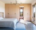 OPPOSITE White-stained hemlock cabinetry with Dekkor pulls. Wave chandelier, custom headboard, and built-in side tables by Bloomster and RCC. Kush rug.