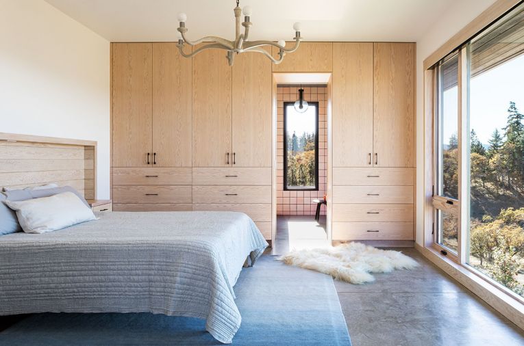 OPPOSITE White-stained hemlock cabinetry with Dekkor pulls. Wave chandelier, custom headboard, and built-in side tables by Bloomster and RCC. Kush rug.