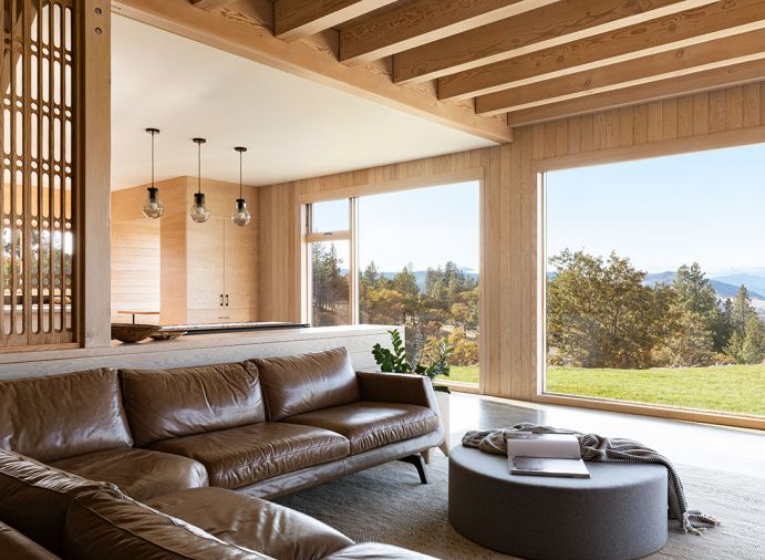 American Leather sectional draws eye to antique carved organ screens artfully framing the two-story staircase. Softline Drum Pouf wide ottoman adjoins another Kush rug.