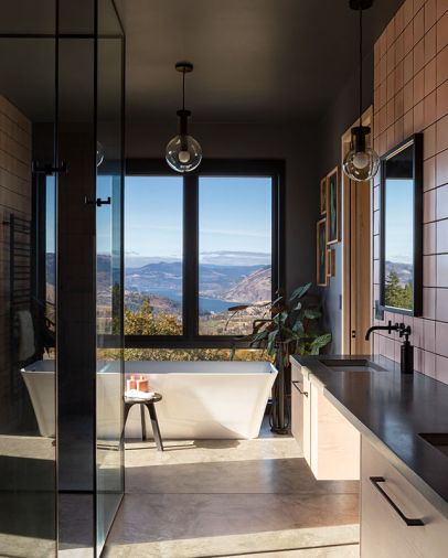 Ann Sacks Black Matte tile boldly frames view making it pop, says Brown. Crosswater London Palermo Grande bathtub creates angular counterpoint to poured concrete radiant heated floors and Pink Pratt & Larson tiles. Raak Amsterdam Maxi-Globes.