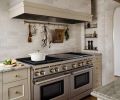 Interior designer Kat Lawton transformed this Mercer Island kitchen so it not only functions better, but suits its Tudor-style surroundings. Details make the difference, like an inset, tiled niche for spices with a brass gallery rail system from Paxton Hardware and a utensil rail from Rejuvenation.