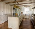 All of the cabinetry was designed by Kat Lawton Interiors and fabricated by Northwest Custom Interiors, with the face of the built-in appliance cupboard subtly reflecting a four-centered arch motif. The doors pocket for easy access to the interior. The cabinet color throughout is Benjamin Moore ‘Inner Balance,’ and the brass hardware is a mix of Rejuvenation and House of Antique Hardware.