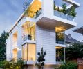 The concrete, steel and glass home is clad in white-glazed Argeton Terracotta panels. Fleetwood windows pair with C.R. Laurence Co., Inc. frameless glass sliding Bi-Part doors.