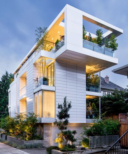 The concrete, steel and glass home is clad in white-glazed Argeton Terracotta panels. Fleetwood windows pair with C.R. Laurence Co., Inc. frameless glass sliding Bi-Part doors.