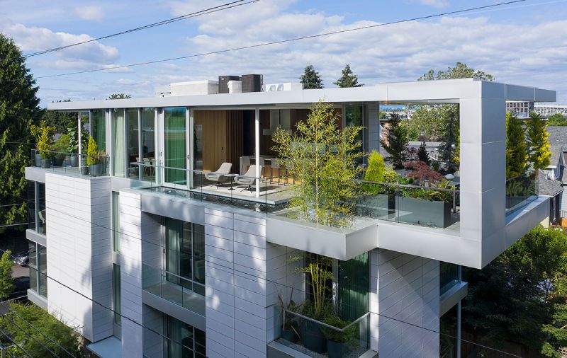 Exterior drone shot captures the glazed Argeton Terracotta panels along the Skyview front exterior. Entry door is directly below. Reflecting pond wraps past kitchen seating area to terrace alongside opening expressly designed to allow the lofting bamboo to rise through it to the fourth floor creating further privacy for the terrace.