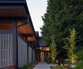 The entry sequence includes uplit gardens and a water feature, as well as a gate to the outdoor room.