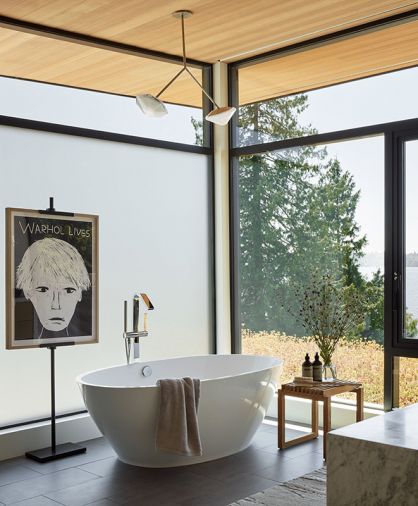 In the primary bathroom, a freestanding MTI tub sits on porcelain tile floors, accented by Dornbracht plumbing and a Gabrielle Scott pendant.