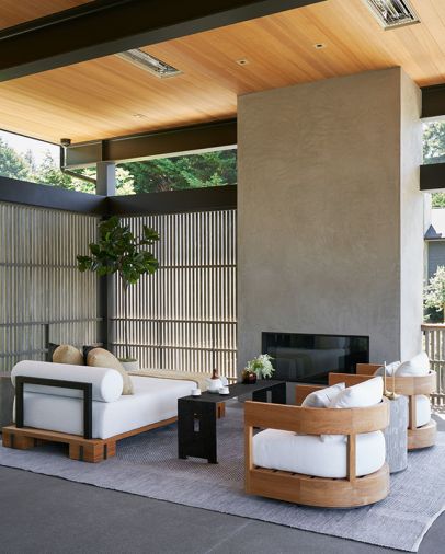 The outdoor room is ready for year-round use, thanks to a Summit chaise and Restoration Hardware chairs clustered before a Da Vinci fireplace, with a Serena & Lily rug, and a Gregorius Pineo coffee table from Kelly Forslund at the Seattle Design Center.