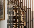 Alchemy Building Company built the custom wine system tucked under the stairs on the bottom floor. The walnut slats come down to a glass door, and the bottles are backlit for artful display.