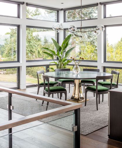 Inside, contemporary, but warm, modern shapes are finished with traditional fabrics and materials like the lush green velvet on these Redford House chairs upholstered in Donghia Fabrics.