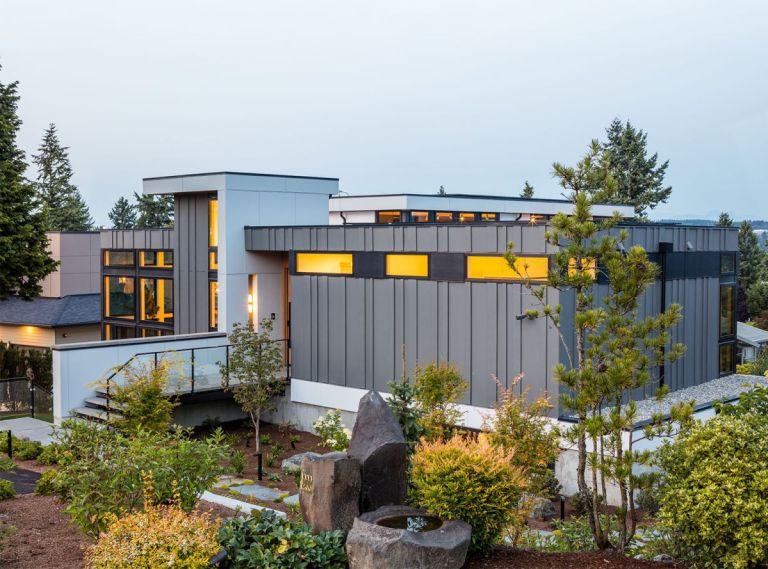 The home’s exterior is decidedly modern, including Hardi Panel and Trim Lap siding painted in a sleek Charcoal and Black Ink from Benjamin Moore. The custom door by Pivot Door Company is reached via an elevated walkway.