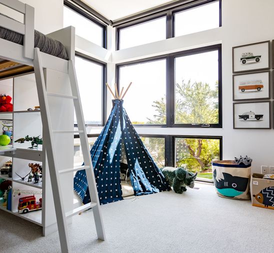 Custom cabinets in family and entertainment room are complementary to the white cabinets upstairs. The children’s rooms accommodate special interests and collections with built-in storage and display fixtures.