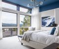 The main bedroom is coolly sophisticated, with a painted ceiling of “Stiffkey Blue” by Farrow and Ball reflective of the original artwork by Corrie Lavelle and the lake views beyond. Casamance custom drape fabric sourced from Kelly Forslund Inc. at the Seattle Design Center softens light in the sun-drenched space.