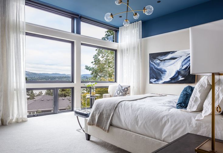 The main bedroom is coolly sophisticated, with a painted ceiling of “Stiffkey Blue” by Farrow and Ball reflective of the original artwork by Corrie Lavelle and the lake views beyond. Casamance custom drape fabric sourced from Kelly Forslund Inc. at the Seattle Design Center softens light in the sun-drenched space.