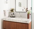 The guest bath also features a custom vanity in walnut and dolomite, with a Rejuvenation mirror, Ann Sacks floor tile, and sconce from Worley’s Lighting.