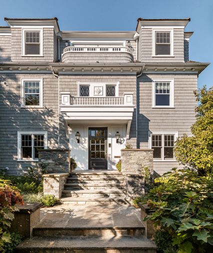 Gone are odd rooflines and choppy exterior with conflicting styles, unified by a Colonial New England style, specific proportions, tall rectangular windows, stained shingles and a whole new third floor.