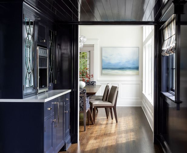 By widening the entrance to the newly created butler’s pantry, which includes a True under-counter wine storage and Dacor wine station whose glass doors continue the leaded glass theme, Studio AM Architects also opens easy access to formerly closed-off kitchen. Light dances off the jewel-toned Benjamin Moore Evening Sky. Walnut dining table and fabric and leather chairs are Holly Hunt. Chandelier John Pomp from Trammell-Gagné at the Seattle Design Center. Existing but refinished 2.5' hardwood dining room floors custom stained.