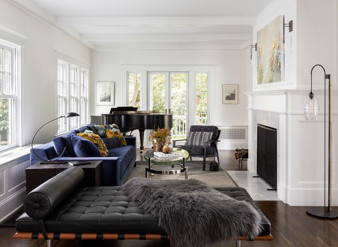 Krieg enlivens living room with black leather Barcelona bench, Restoration Hardware faux throw and blue velvet Holly Hunt sofa. Pop of orange from Housewright pillows. John Pomp Studios floor lamp. Michael Schultheis artwork from Winston Wachter Fine Art.