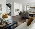 View from living room of floating staircase, dining, and kitchen layout. Sub-Zero custom paneled refrigerator. Easy-to-maintain cabinetry features hardware fit to homeowner’s hand.