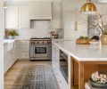 Brass Rejuvenation sconces and hardware accent custom Superior Cabinets in Agreeable Gray by Sherwin Williams. Wolf range, Carrara marble countertops, backsplash. Rohl plumbing. Found Home Shop rug.