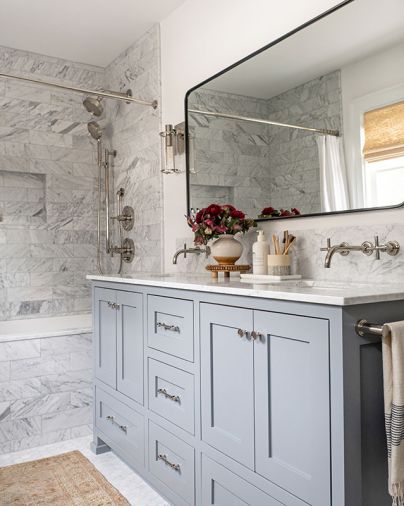Son’s bathroom reiterates Carrara marble countertops with nickel Kohler plumbing. Rounded Rejuvenation vanity mirror and sconces.